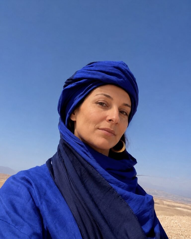Sahara 3 A traveller in a violet turban beside a camel caravan crossing the golden dunes of the Moroccan Sahara